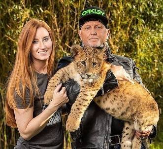 Lauren Lowe and Jeff Lowe with an exotic cub